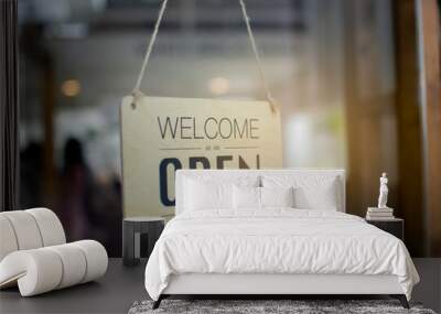 A wooden sign hanging in front of a mirror at the entrance of the coffee shop Concept of opening shop in the morning Wall mural