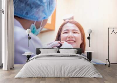 Doctor dentist treats teeth of a beautiful young girl patient. Wall mural