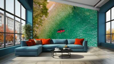 The top view of two tourist paddling their red kayak at the beatiful blue seashore in summer Wall mural