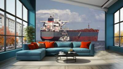 BULK CARRIER - The ship sails from port to sea secured by tug
 Wall mural