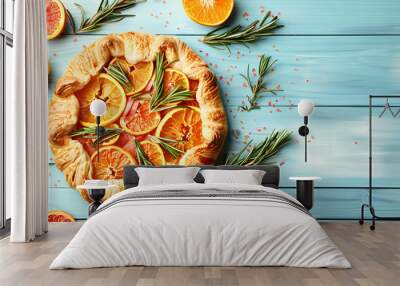 Delicious galette with citrus fruits and rosemary on blue wooden table, flat lay Wall mural