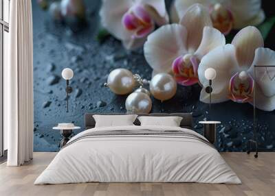 Elegant pearl earrings and orchid flower on black background, closeup Wall mural