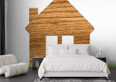 Wooden home icon on grass isolated on white Wall mural