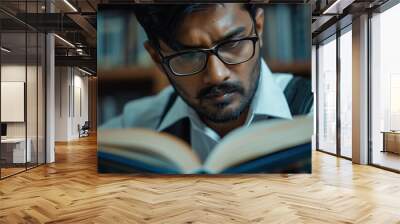 Focused Indian business man reading a book in office closeup. Wall mural