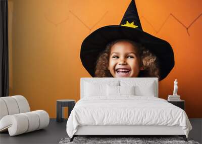 Happy laughing child girl in witch costume to Halloween on color background Wall mural