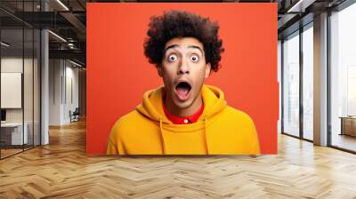 young man expressing surprise and shock emotion with his mouth open and wide open eyes. isolated on color background Wall mural