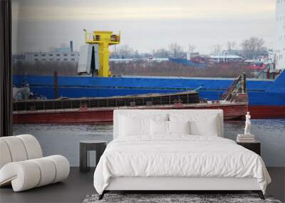 Blue cargo ship and barge with cargo on the river Severnaya Dvina. Wall mural