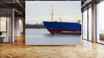 Blue cargo ship and barge with cargo on the river Severnaya Dvina. Wall mural