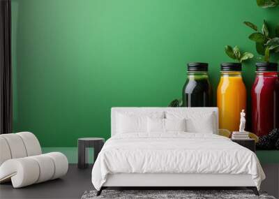 A green background with four different colored bottles of juice on it Wall mural