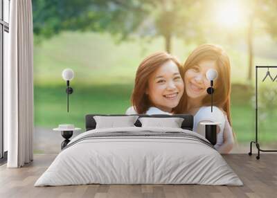 Asian adult sisters outdoor fun Wall mural