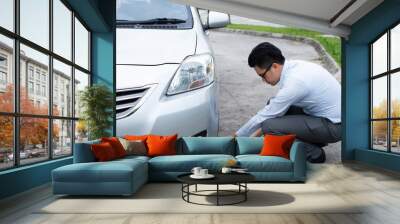 asian business man pumping air into car Wall mural