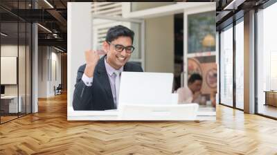 young indian business male on laptop and coffee at a cafe with h Wall mural