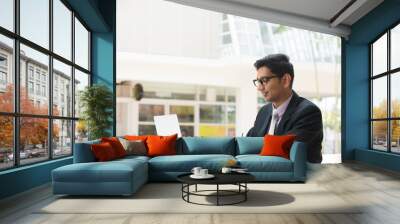 young indian business man on laptop and coffee Wall mural