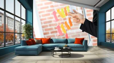 pointing on glass wall with glued colorful paper notes. Note paper reminder schedule board. Business people meeting and use post it notes to share idea. Discussing - business, teamwork, concept Wall mural