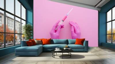 Hands of a medical professional in pink latex gloves with a syringe. Medical concept. Top view mock up Wall mural