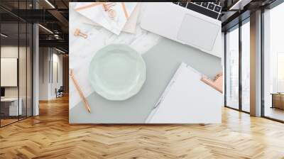 Women's blogging pastel background. Office desk workspace with a tea cup, clipboard, spring tulip bouquet, hat and laptop on a marble background. Top view with copy space Wall mural