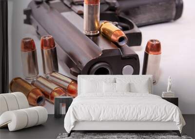 A black 40 caliber pistol with eight 40 caliber hollow point bullets on a white background Wall mural