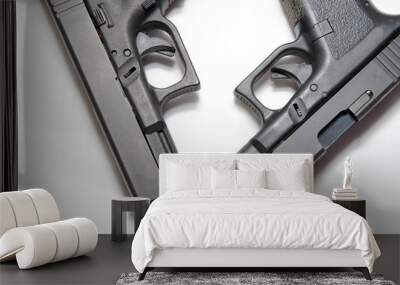 Two black semi automatic pistols, a 9mm and a 40 caliber on a white background showing the different sizes of them Wall mural