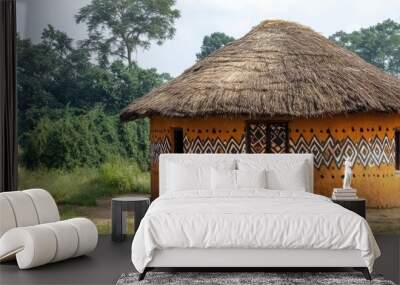 A traditional African mud house with a thatched roof, decorated with geometric patterns, illustrating the cultural significance and sustainability of local architecture Wall mural