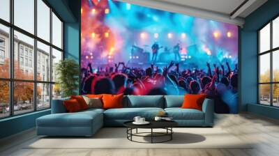 A crowd of people are at a concert, with the stage lit up in bright colors Wall mural