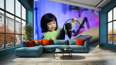 cute baby girl singing with headphone recording new song with microphone in the home recording studio Wall mural