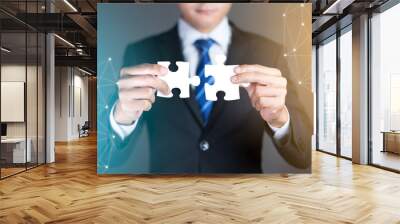 businessman hands connecting puzzle pieces representing the merging of two companies or joint ventur Wall mural