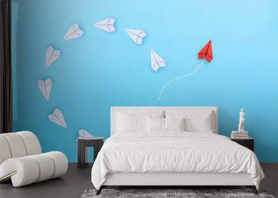 Group of white paper planes fly in a circle and one red paper plane pointing in different way on blue background. Business for new ideas creativity, innovative and solution concept. Wall mural