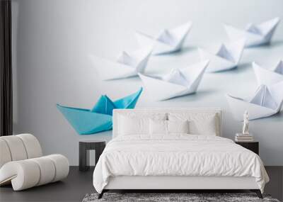 Leadership concept with blue paper ship leading among white on white background. Wall mural