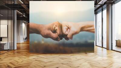 Man giving fist bump in sun rising nature background. power of teamwork concept. vintage tone Wall mural