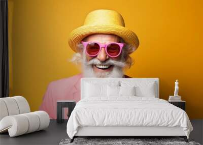 Vibrant and colorful summer concept with a happy old man in a hat and sunglasses sipping an orange juice or cocktail on a pastel background A trendy hipster senior person enjoying Wall mural