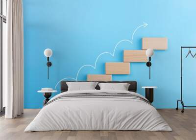 wooden block stacking as step stair with white arrow up on blue background, ladder of success in bus Wall mural