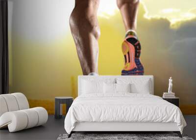 close up feet with running shoes and strong athletic legs of sport man jogging in fitness training sunset workout Wall mural