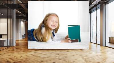 happy cute blonde haired school girl reading a book looking at c Wall mural