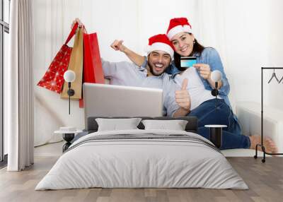 young couple online Christmas shopping with computer Wall mural