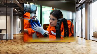 In an electronic parts facility, two female engineers In the plant, inspecting and testing robotic hands used in the production of electronic components. Wall mural