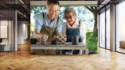 Portrait of a senior Asian couple doing activities together in the pottery workshop. Wall mural