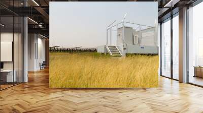 The field of solar panels with an energy storage station located in the middle of a solar cell panel on an area of hundreds of acres Wall mural