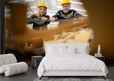 Two factory workers work in a warehouse, pushing a paper cart to be recycled Wall mural