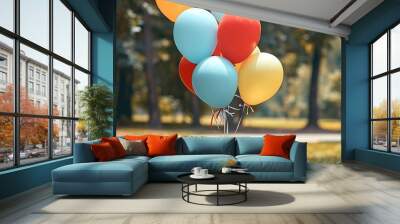 Different colored balloons tied together in a park, celebrating Friendship Day. Wall mural