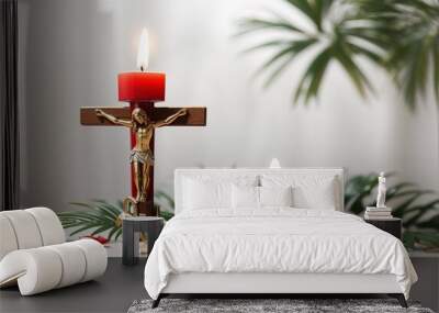 Crucifix with figure of Jesus, red candle and palm leaves on white background Wall mural