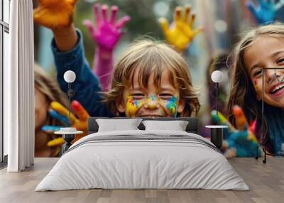 Group of kids laughing and having fun shows dirty hands with colorful paint Wall mural