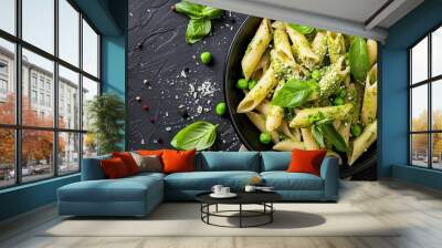 Italian food featuring penne pasta pesto sauce zucchini green peas and basil photographed from above in a flat lay style Wall mural