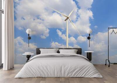 Wind turbine on the green grass over the blue clouded sky Wall mural