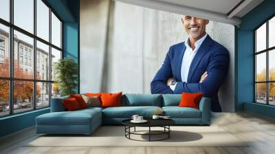 Confident businessman smiling against a concrete wall Wall mural