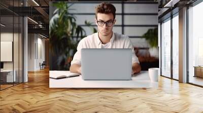 Handsome man working on laptop at home Wall mural