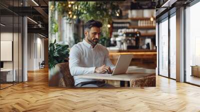 Professional Man Working on Laptop in Cozy Cafe Wall mural