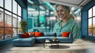 Tech Expert: A confident woman in a green shirt smiles as she utilizes a tablet in a modern server room, showcasing her expertise and technological prowess.  Wall mural