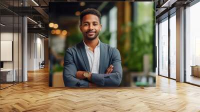 Young manager, leadership and smile of a black man standing with arms crossed in a startup business for motivation, innovation and success Wall mural