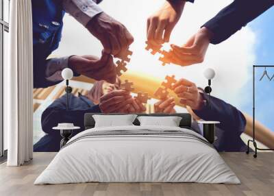 The hand of a businessman holding a paper jigsaw And solve the puzzle together. The business team assembled a jigsaw puzzle. A business group wishing to bring together the puzzle pieces Wall mural