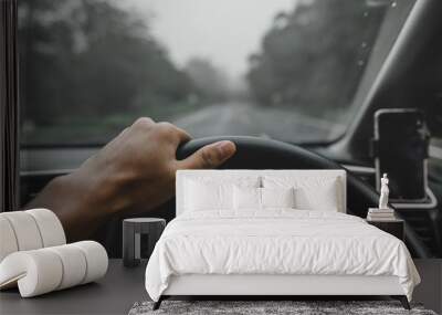 View on the dashboard of the truck driving.The driver is holding the steering wheel. Forest road is in front of the car Wall mural